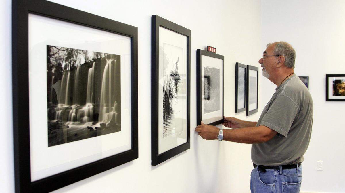 Mike Haskey mhaskey@ledger-enquirer.com 
 Bill Adams checks if a photograph is hanging level Wednesday afternoon at Columbus State University's Rankin Arts Photography Center at 1004 Broadway in Columbus. Adams and Kenny Gray spent Wednesday afternoon haning the 47 photographs that were selcted by jurist Donna Rosser to be included in the Columbus Photographers 2015 show at the center. The photographs, the work of approximately 35 different photographers, span a wide variety of subject matter and are both color and black & white. This is the fourth year for the show, which opens to the public with a free opening reception Friday from 6-8pm. 09/01/15