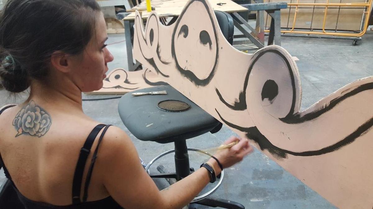 Aileen Fowles, scenic designer for ‘The True Story of the Three Little Pigs’ at work on a piggy bookcase.