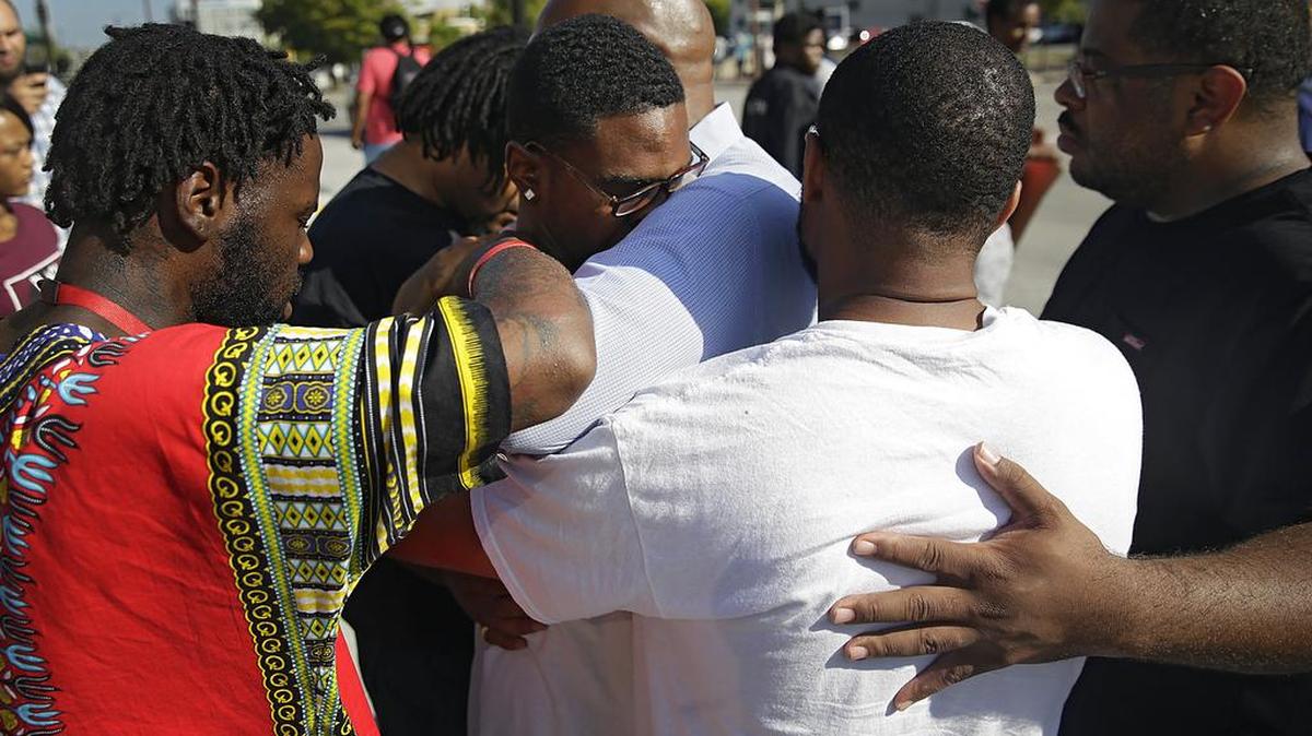 Protesters pray over Tyler Johnson, son of Terence Crutcher, in front of the Tulsa County Courthouse Monday, Sept. 19, 2016, in Tulsa, Okla., during a protest of the Tulsa Police shooting of Terence Crutcher.