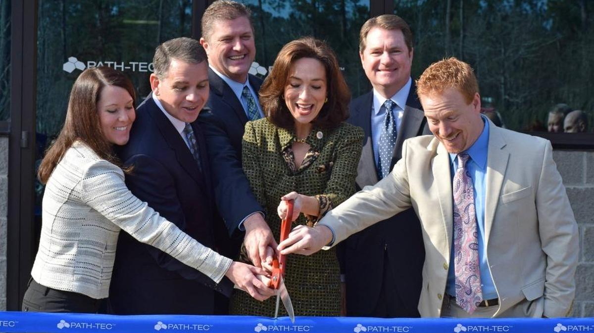 Kevin Boykin, president and CEO of Path-Tec, second from left, with help from Columbus Mayor Teresa Tomlinson, center, cuts the ribbon on the company’s 130,000-square-foot facility in Muscogee Technology Park in February 2016. --