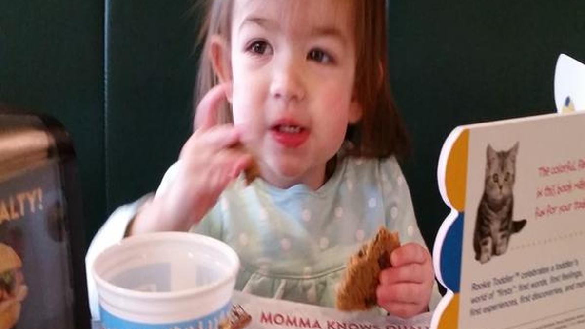 Scarlett, daughter of Momma Goldberg’s staffer Katie Crew, enjoys a treat at Momma G’s while reading her favorite book provided by the organization Reach Out and Read. --