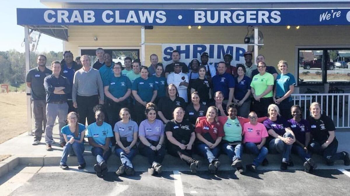 The crew of the Shrimp Basket, which opened its doors Thursday in Columbus, poses for a photo in front of the 6073 Veterans Parkway restaurant. --