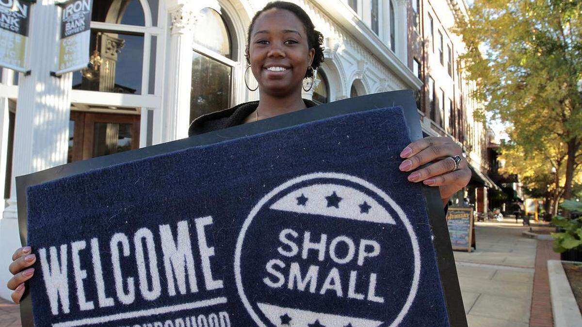 Jena Wittke of Broadway Estate Jewelry holds the welcome for shoppers on Small Business Saturday.