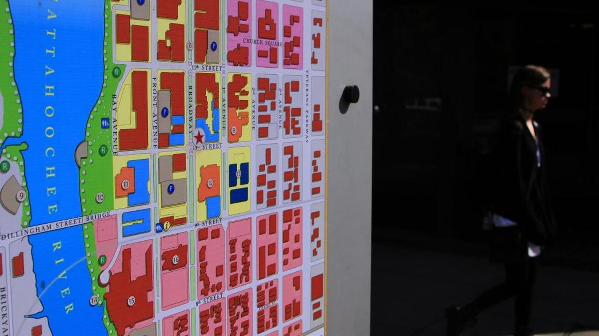 A woman walks past a map showing the downtown Columbus area in the 1000 block of Broadway on Tuesday afternoon.