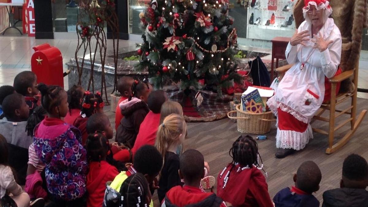 Mrs. Santa Claus, also known as retired library early learning initiative coordinator Lyn Seaman-Leech, reads to Stewart County pre-kindergarten students recently on a Christmas stage at Peachtree Mall. --