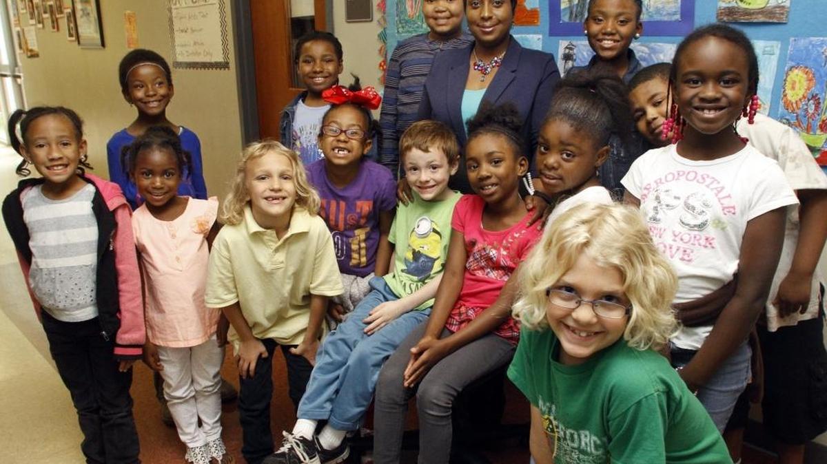 Tiffany Bass-Jackson, center, is surrounded by the students in kindergarten through third grade who have graduated from her Families and Schools Together program at Rigdon Road Elementary School.