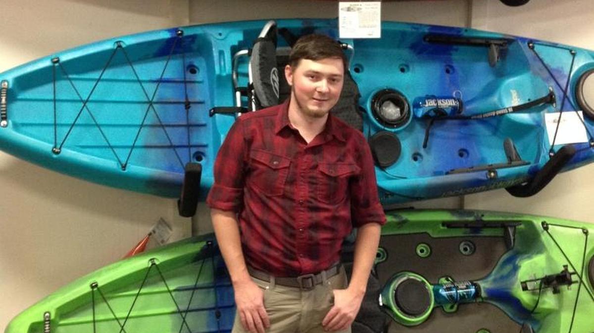Chris Largent, shown with colorful kayaks, is co-owner and manager of Outside World, 1025 Broadway, in Columbus. --