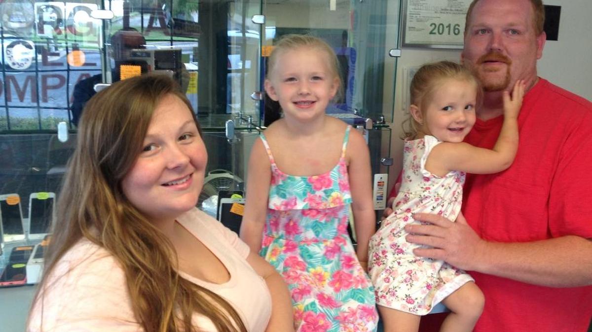 Brandon Heard, at right holding daughter, Kylah, is shown with wife, Allison, and daughter, Kyleigh, at Georgia Cell Company, 3551 Macon Road in Columbus. Heard is a smartphone and electronic device technician who also manages the store, with help from Allison. --