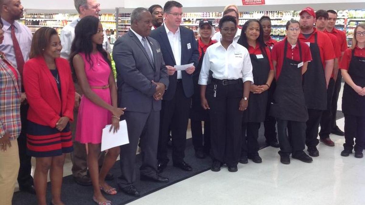 Winn-Dixie Regional Vice President Drew Elkins, center, presents $5,000 check to Phenix City Mayor Eddie Lowe for a scholarship program at Chattahoochee Valley Community College on Friday at the Ladonia store.