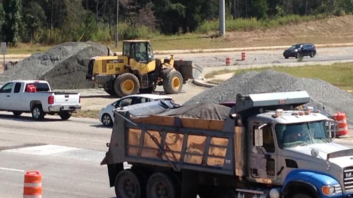 Construction equipment and trucks long, shown here Thursday, have been sharing the road on a stretch of Veterans Parkway in north Columbus, here at parkway’s intersection with Moon and Williams roads. --