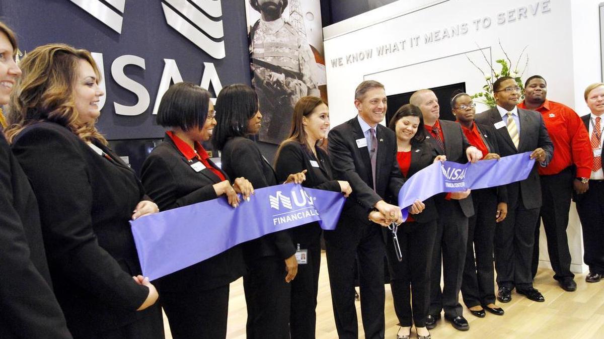 USAA executives and employees cut the ribbon for the financial center’s grand opening on Veterans Parkway in Columbus on Jan., 10, 2014. The center had a soft opening in December 2013. The office will close its doors on Friday, but is installing three ATMs in the city for customers to use.