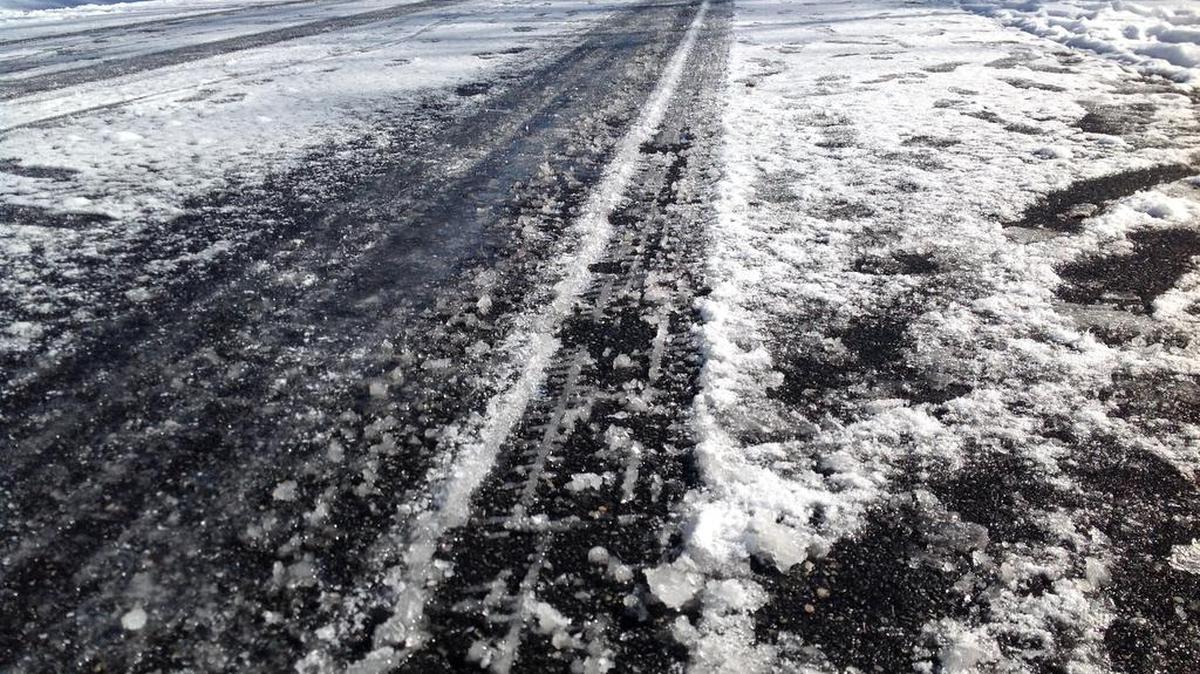 A snowy and crunchy ice-coated road entering the lunch hour Wednesday in a Smiths Station, Ala., neighborhood.