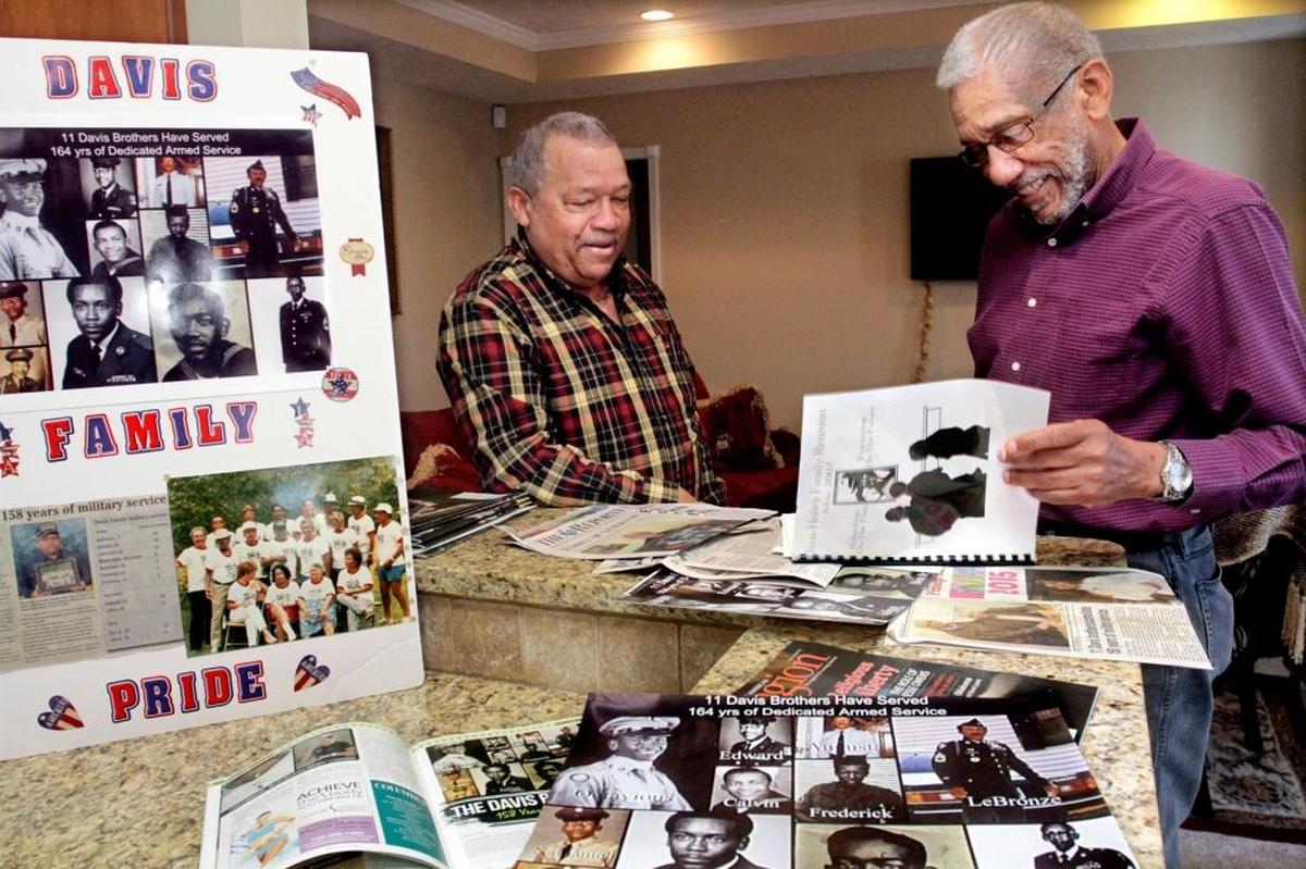 Vietnam veteran Lebronze Davis, of Phenix City, Ala., left, and his brother Nathaniel Davis, of Montgomery, Ala., look through memorabilia and articles about the 11 Davis brothers from Wetumpka, Ala., who served a total of 158 years in the U.S. Armed Forces. The Davis’ and nine brothers served in the U.S. Army, the U.S. Navy and the U.S. Air Force. Two brothers and three daughters from the large farm family did not serve in the military.