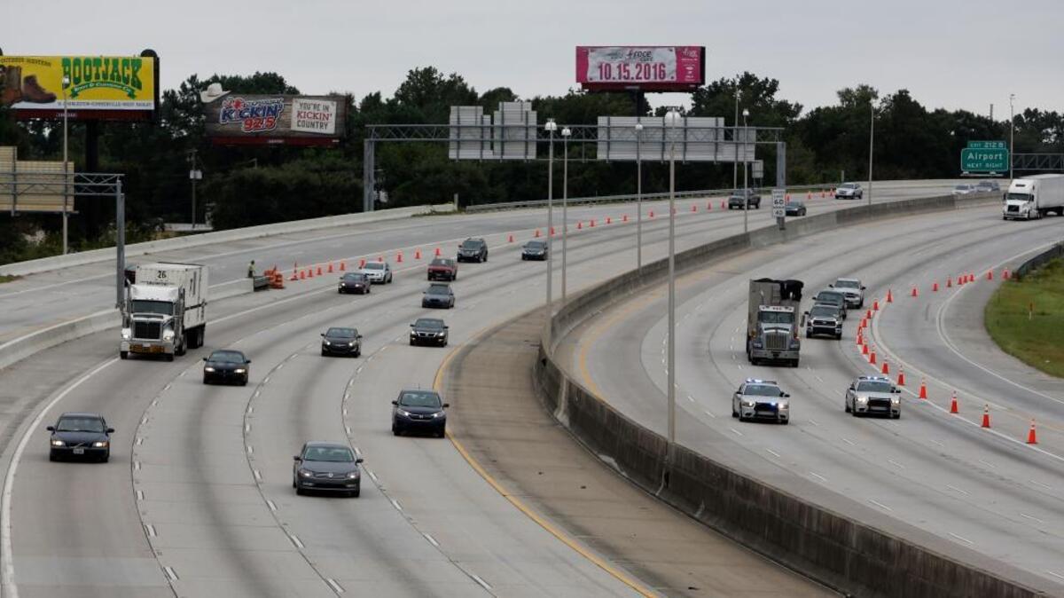 South Carolina state troopers, right, lead the first wave of cars evacuating on the reverse lane of Interstate 26 Wednesday, afternoon, Oct. 5, 2016, as traffic headed towards Columbia, S.C., near the Remount Road overpass in North Charleston, S.C., in advance of Hurricane Matthew. (AP Photo/Mic Smith)