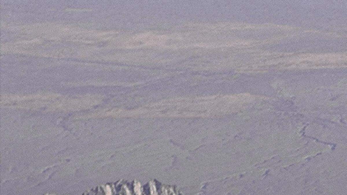Dryden's SR-71B Blackbird, NASA 831, slices across the snow-covered southern Sierra Nevada Mountains of California after being refueled by an Air Force tanker during a 1994 flight. SR-71B was the trainer version of the SR-71. The dual cockpit to allow the instructor to fly. Note the streaks of fuel from refueling spillage.