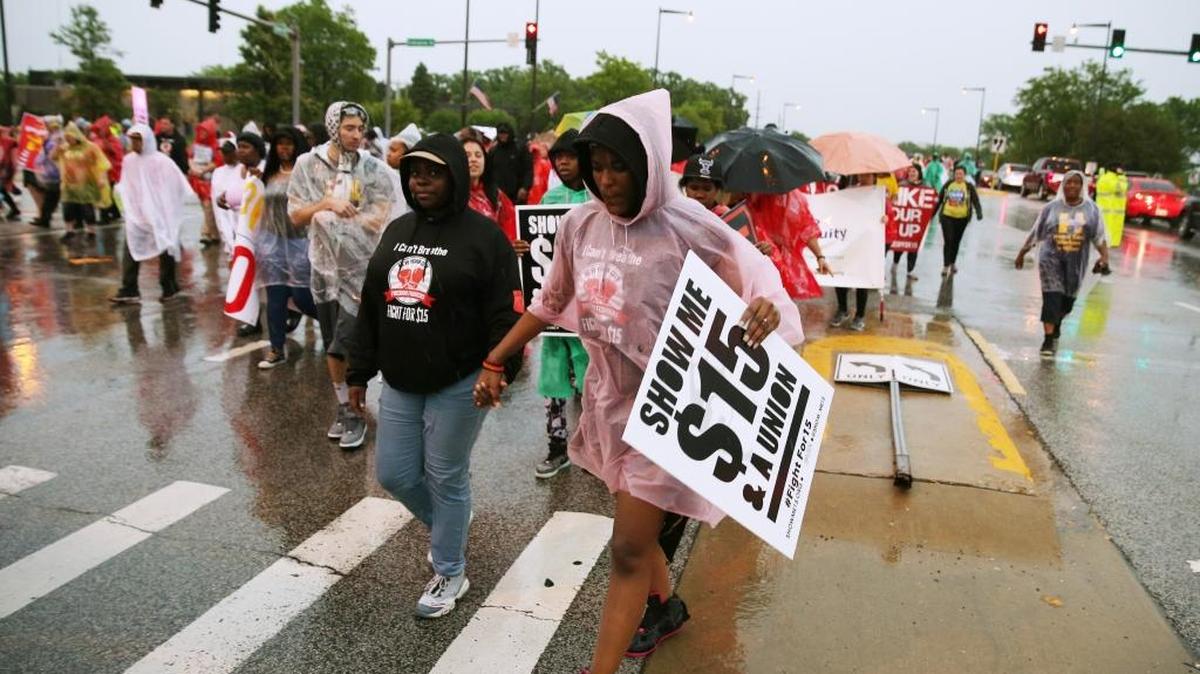 Minimum wage won’t pay the rent in Columbus and other cities across the nation. Protesters march to demand $15 per hour pay along in Oak Brook, Ill.