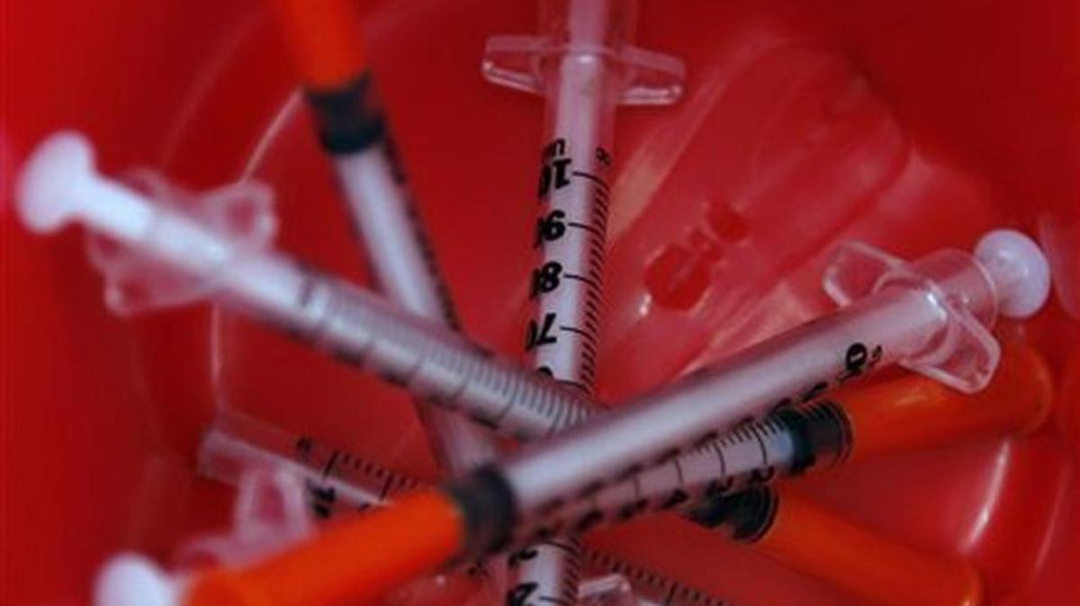 In this Friday, Sept. 18, 2015 photo, used syringes sit in a bin after being disposed by heroin addicts in exchange for a kit containing new ones in Dosquebradas, Colombia.