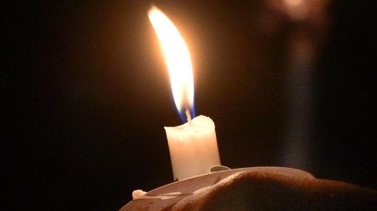 A Columbus mourner holds a lit candle in 2016.