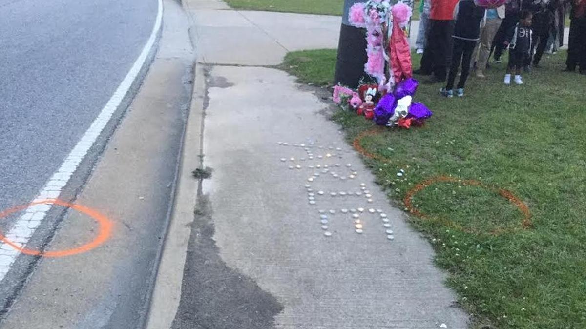 Family and friends remember Arie Phillips with her name spelled with candles on Flat Road Road during a vigil.