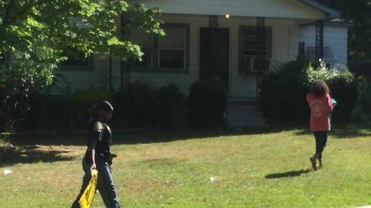 A Columbus police officer removes crime scene tape Saturday morning from this house at 5908 Hodges Road where Richard Collier was fatally shot.