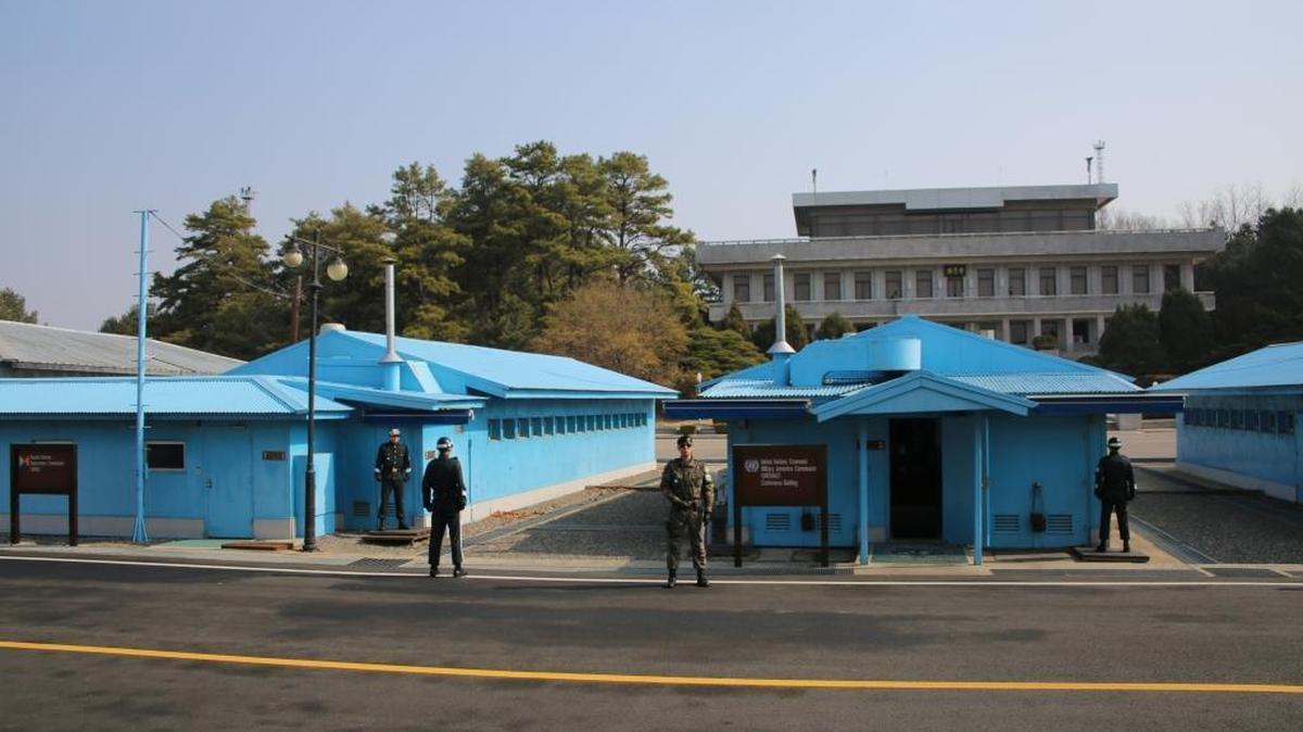 This photo taken during this past spring shows part of the Joint Security Area in the Demilitarized Zone along the border separating democratic South Korea and communist North Korea. The Military Demarcation Line runs through the middle of the purple U.N. buildings. An American soldier faces the camera. The other soldiers, in the blue uniforms, are with the United Nations. North Korean guards are on the other side of buildings, not seen in the photo. Everything on the other side of the purple buildings is in North Korea. The large building in the background is North Korea's DMZ headquarters.