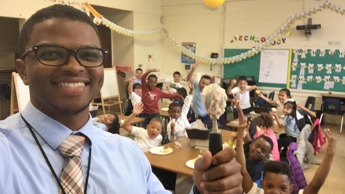 Kindergarten teacher Pocco Bussey, a U.S. Air Force veteran and Columbus, Ga., native now in the Teach for America program, poses with his students at Thomas S. Stone Elementary School in Mount Rainier, Md., during the party to celebrate the end of the second quarter in the 2015-16 school year.