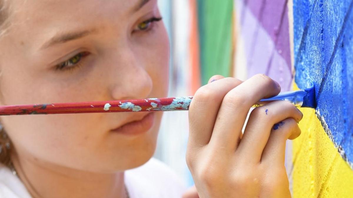 Lindsey Calhoun focuses Friday, October 6, 2017, on some of the details of the 85-foot-long mural Columbus State University students are painting on the exterior of the Davidson Student Center,