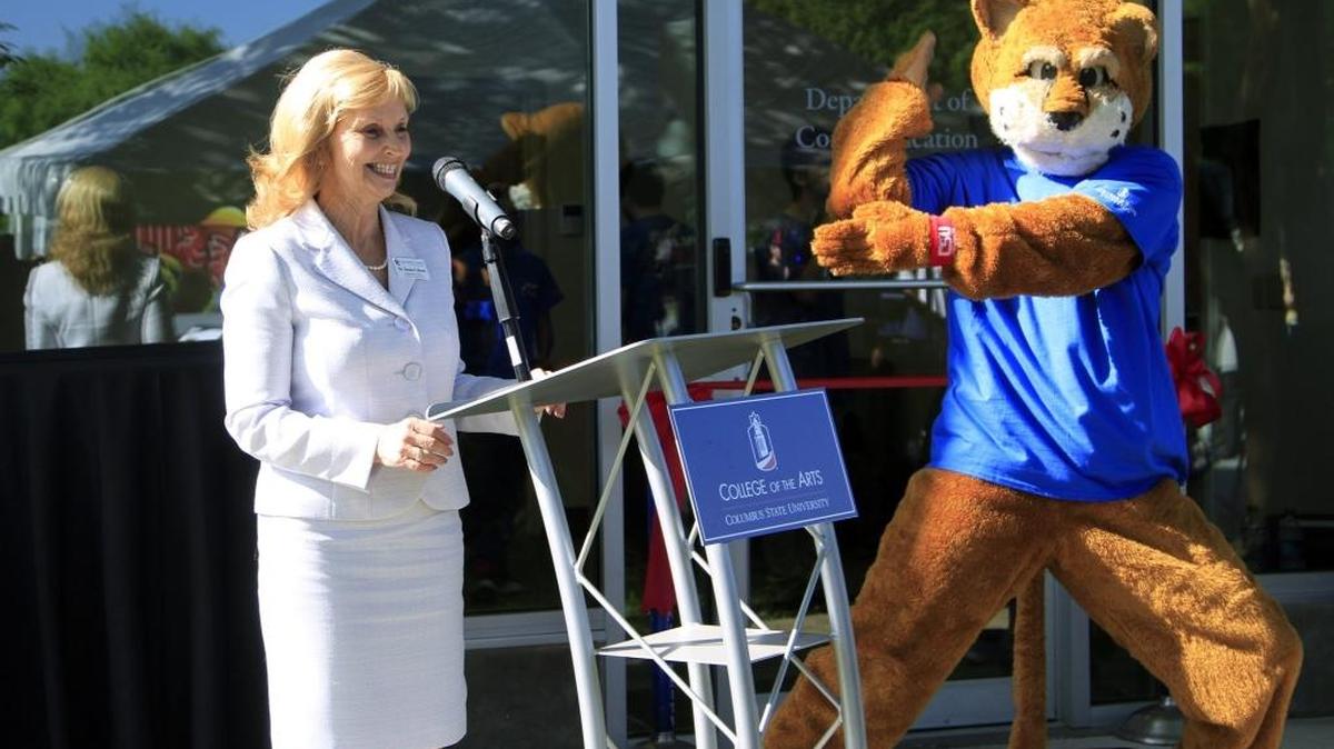 Danna Gibson, chair of the department of communication at Columbus State University, jokes Thursday morning with Cody the Cougar during a ribbon-cutting and launch celebration for 88.5 WCUG Cougar Radio. CSU's Department of Communication honored James "Jimbo" Martin, the benefactor of 88.5 WCUG Cougar Radio, and celebrated the station's official launch during the Thursday morning program. 04/21/16