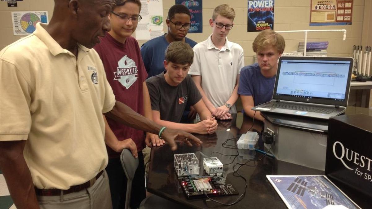 Calvary Christian School of Columbus science teacher Ed Tymes shows students an experiment about heat radiation Sept. 18, 2017, as they participate in the Quest for Space program, which allows them to create an experiment that, if it meets NASA specifications, will fly aboard the International Space Station. Pictured from left are Tymes and students Guy Worley, James Brewster (sitting), Galen Jones, Beau Kirkland (white shirt) and Ben Whitted.
