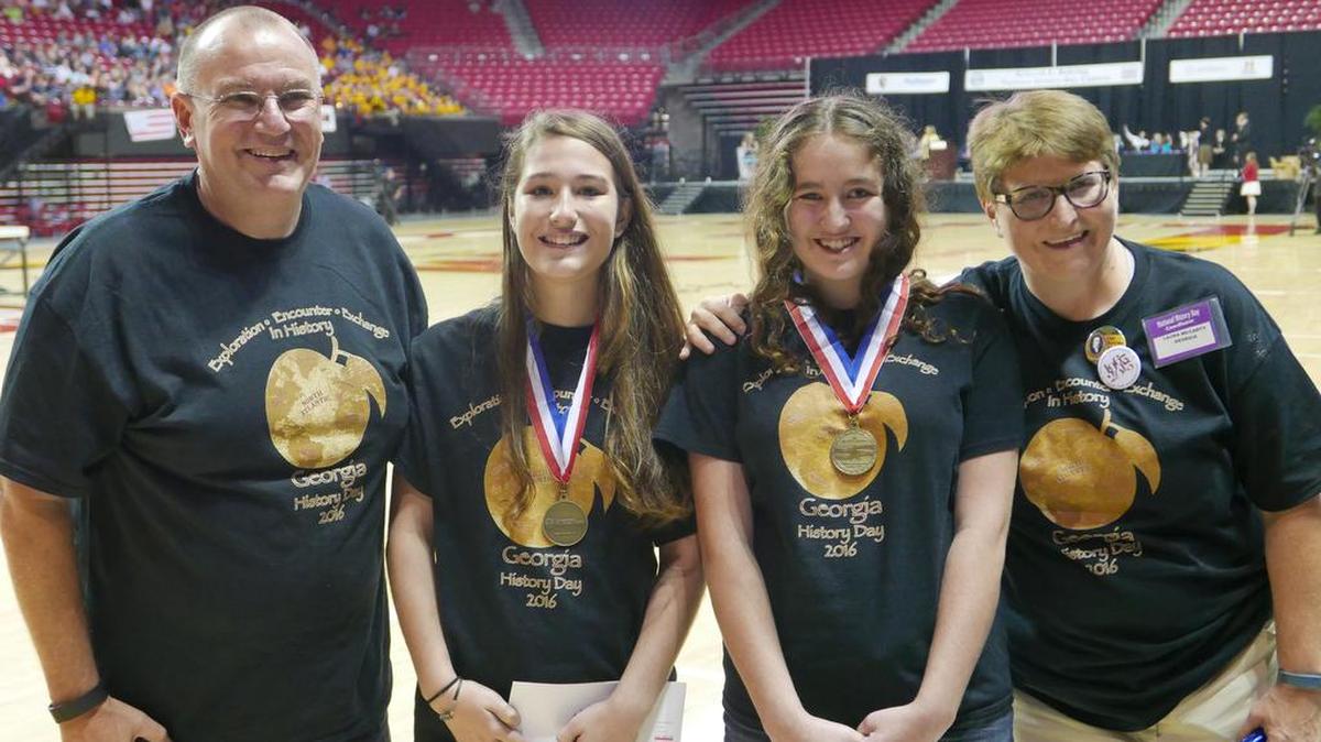 Genevieve Haskins of Manchester, center left, and Eleanor McCoy of Columbus, center right, pose with the gold medals they won this month in the National History Day competition at the University of Maryland. Pictured with them are NHD Georgia state coordinators Kevin Shirley, a LaGrange College history professor, and Laura McCarty, vice president of the Georgia Humanities Council.