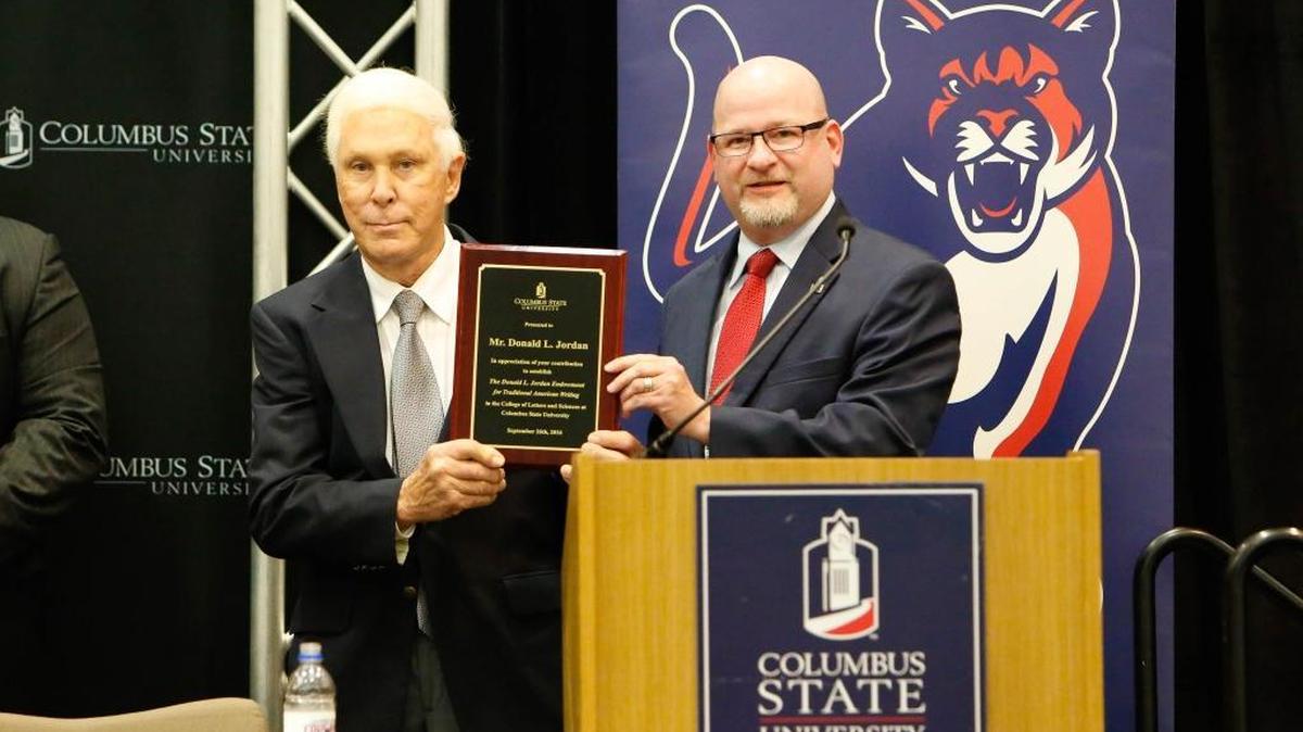 Columbus businessman and author Donald L. Jordan, left, receives a plaque of appreciation from Columbus State University president Chris Markwood on Sept. 26, 2016, to thank him for his $3 million gift to establish and endowment for fostering the art of writing at CSU.