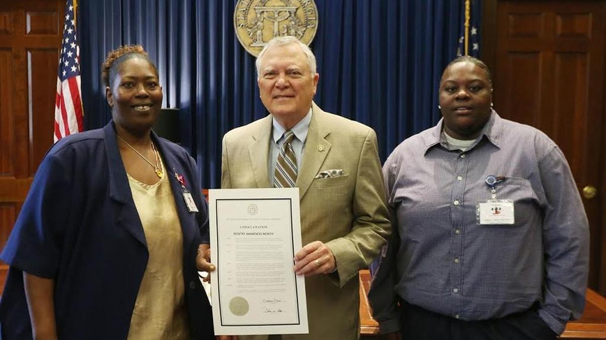 Waleisah Wilson and Temeka Menefee, of NewLife Second Chance Outreach Inc., receive a proclamation from Gov. Nathan Deal declaring July 2016 Reentry Awareness Month.