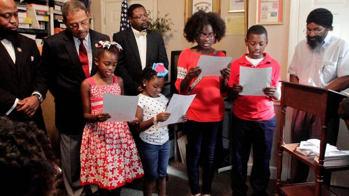 Students read the Creed of African/Black America during a check presentation at the Columbus Black History Museum and Archives. U.S. Rep. Sanford Bishop, second from left, presented Johnnie Warner, right, the museum founder and director, with a check for $5,000 from the Black History Observance committee. Back row from left: Dave Gillarm, grand historian for Prince Hall Grand Lodge of Georgia; Bishop; and committee chairman Teddy Reese, Esq. Front row from left: Skylar Lewis, 9, Amber Ray, 6, Kayle Lewis, 12, Andrew Lewis, 11, and Warner.
