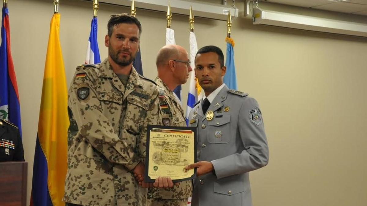 A Panamanian police officer at right displays his German Armed Forces Gold Badge for Military Proficiency during a graduation Nov. 3, 2016 at Fort Benning.