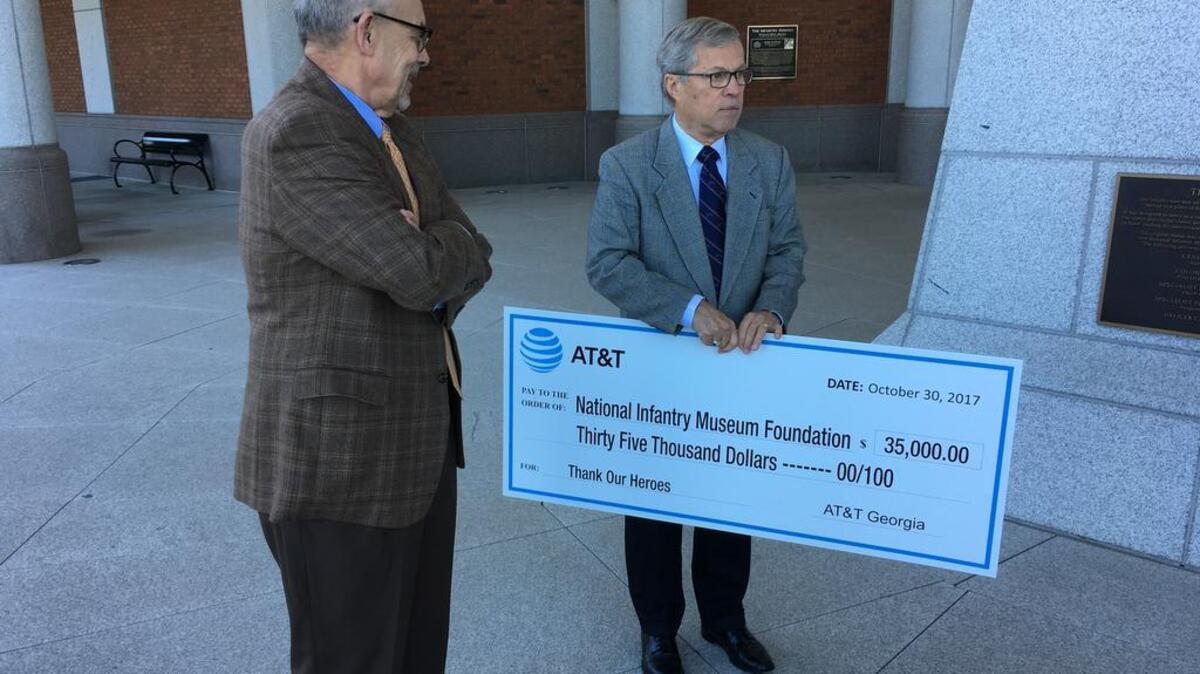 AT&T Regional Director of External Affairs Terry Smith, left, presents National Infantry Museum Foundation President and COO Greg Camp with a ceremonial check on Monday.