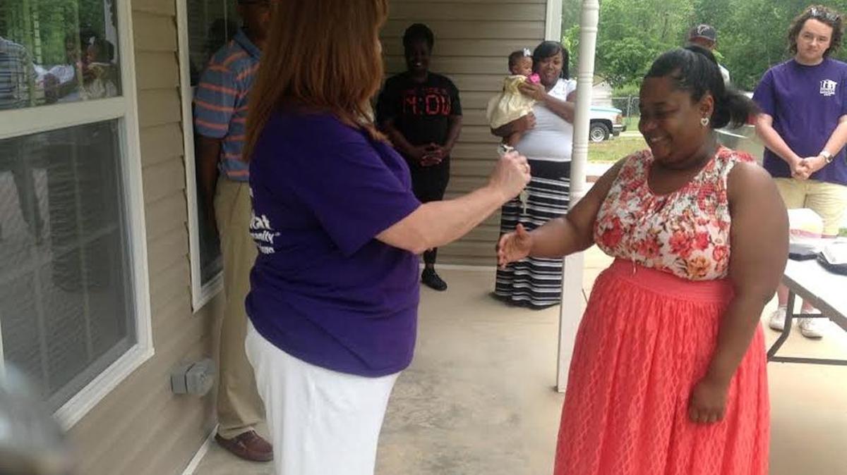 Connie Ramsay-Austin of Habitat for Humanity, at left, presents keys to new homeowner Kiara James of Phenix City on May 20, 2017.