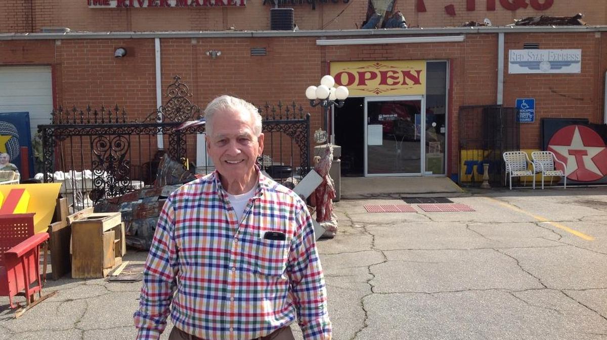 Allen Woodall, owner of River Market Antiques, poses in front of his business.