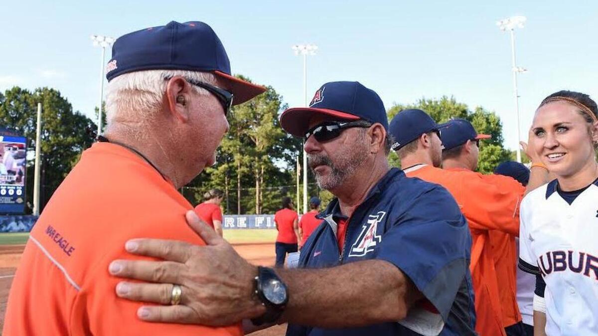 Auburn Coach Clint Myers, left, shakes the hand of Arizona Coach Mike Candrea on Sunday. Candrea won one of his national titles in Columbus 20 years ago.