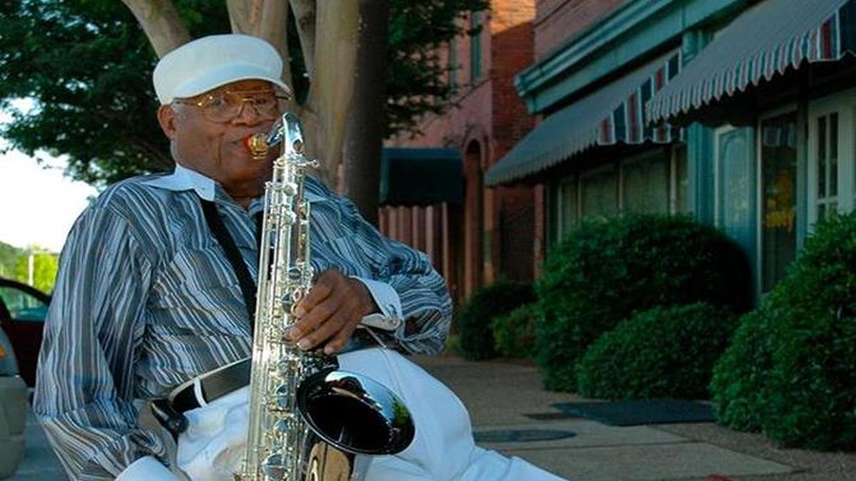 Longtime Columbus resident Ed Cox plays his saxophone along First Avenue. Cox died last month at 94.