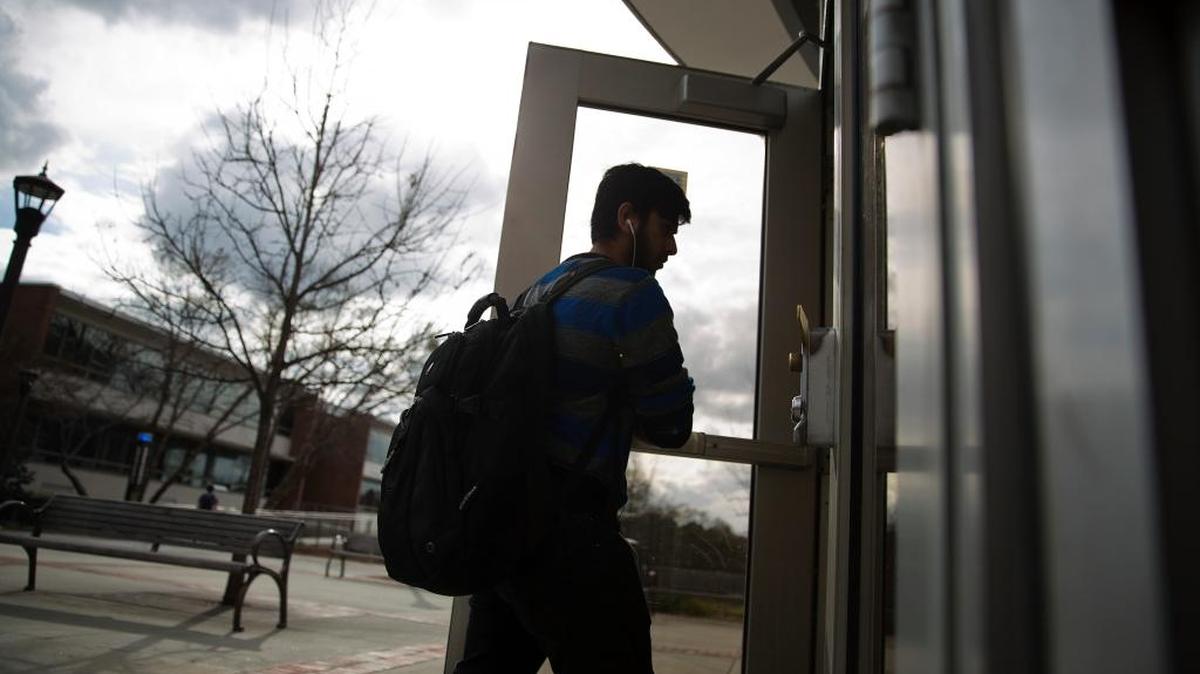 A pedestrian walks into the library on the Georgia Tech campus Friday in Atlanta. Licensed gun owners who are 21 and older would be able to carry concealed weapons on public college campuses in Georgia if Gov. Nathan Deal signs a bill headed to his desk.