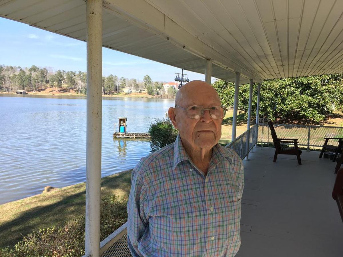 Dewey Reaves stands on the porch of his home on Lake Oliver as he discussed his 100th birthday on March 16, 2018.