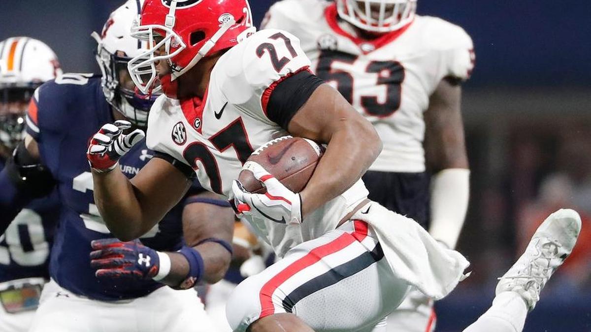 Georgia running back Nick Chubb (27) runs near Auburn defensive lineman Dontavius Russell (95) during the first half of the Southeastern Conference championship NCAA college football game, Saturday, Dec. 2, 2017, in Atlanta.