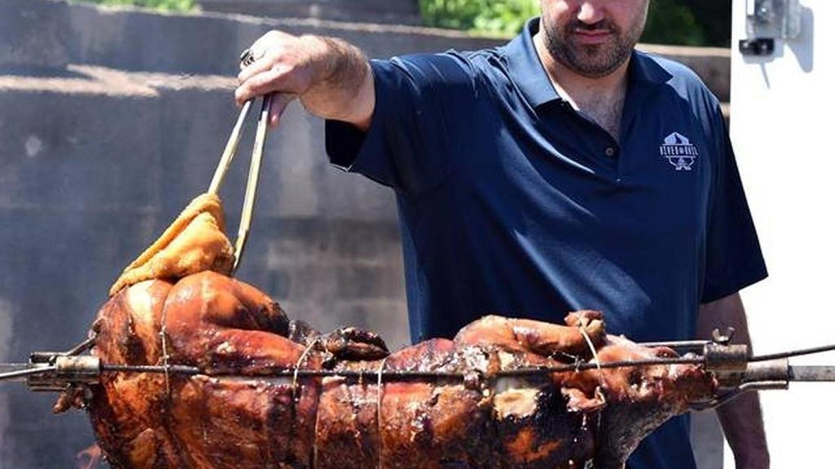 Dimon moved to Columbus because of the warm and friendly people, and also because around here people apply barbecue sauce with mops — and baste whole hogs in butter. That’s River and Rails’ Brand Andries basting a whole hog in butter.