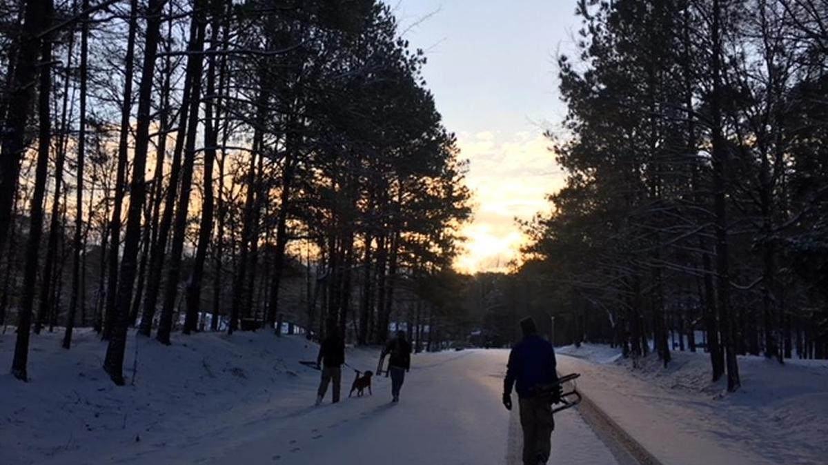 The part of the Kendrick-Holmes family that hasn’t left Columbus yet, including dog Dexter, walk through the woods on a snowy morning.