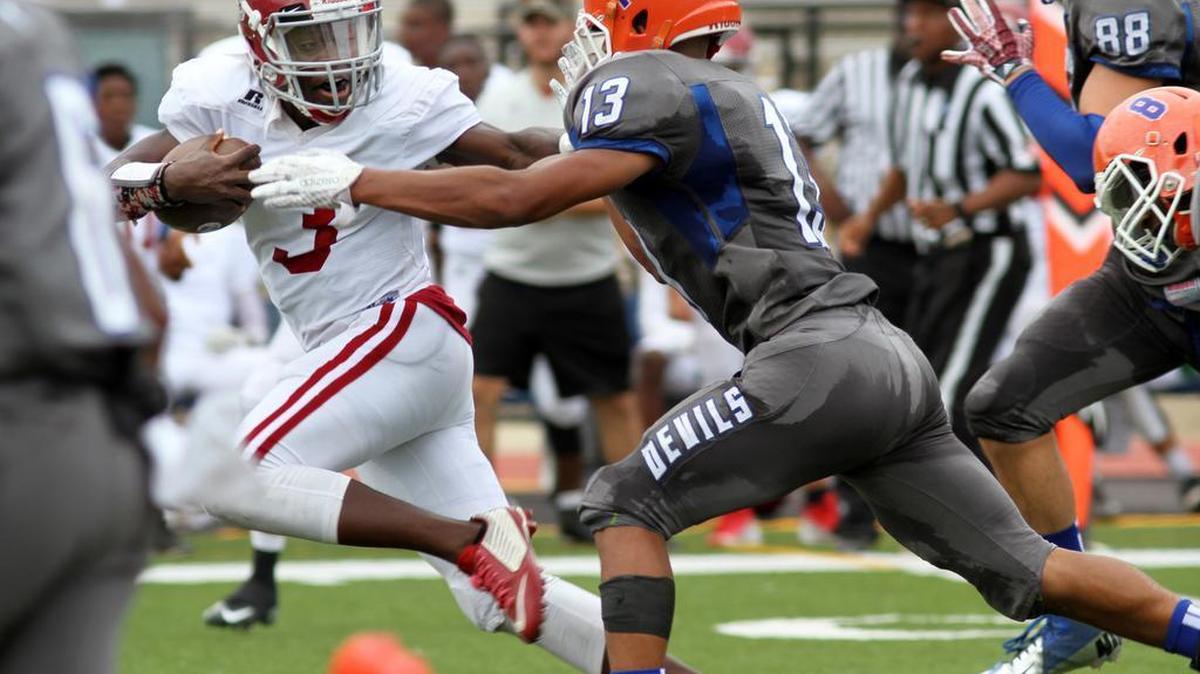 Jordan High's Emmanuel Mann stiff arms Jordan High's Anthony Bonner on his way to a 61-yard touchdown run during the Muscogee County School District Fall Classic at Kinnett Stadium Saturday. The Blue Devils beat the Red Jackets 47-32.