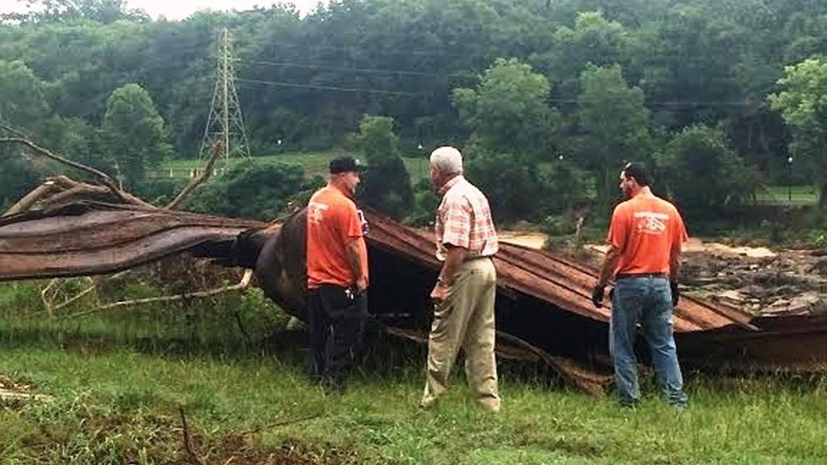 Bill Reeves, center, and two crew members look over a huge piece of steel they plan to cut up and haul away from the Chattahoochee’s banks.