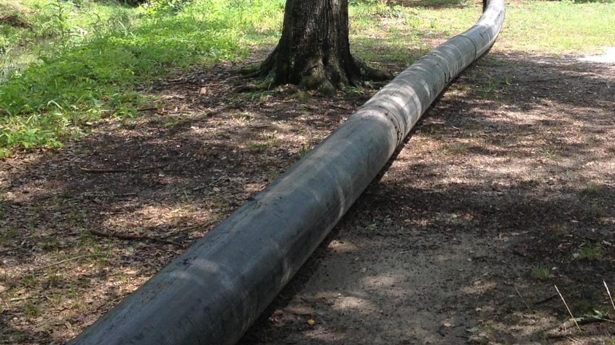 Hundreds of feet of black pipe lay alongside Weracoba Creek.