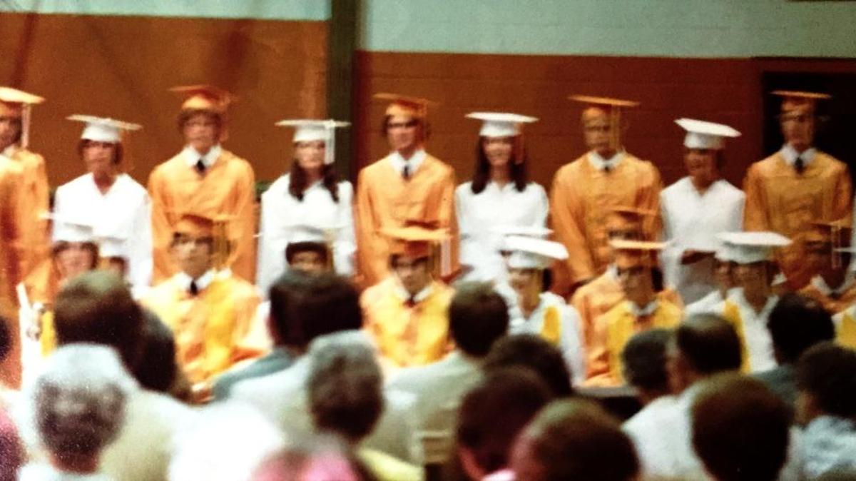 Dim lighting and a slow shutter speed make 1978 high school graduates blur on Kodachrome film.