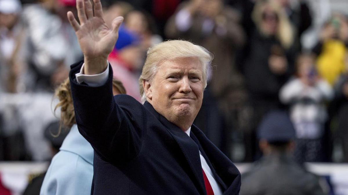 President Donald Trump waves as he walks in his inaugural parade on Pennsylvania Avenue outside the White House in Washington, Friday, Jan. 20, 2017.