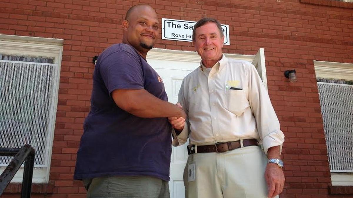 Samuel Jones poses with SafeHouse Ministries Executive Director Neil Richardson on Tuesday.